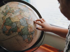 child pointing at Africa on globe